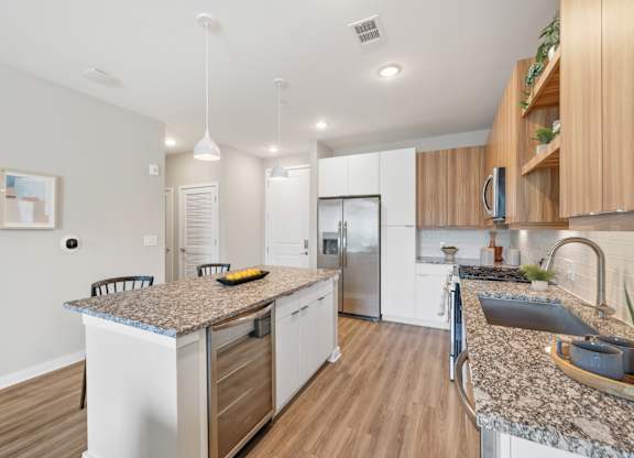 A modern kitchen with granite countertops and stainless steel appliances.