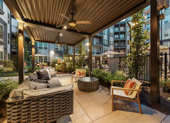 A patio with a couch, chair, and table.