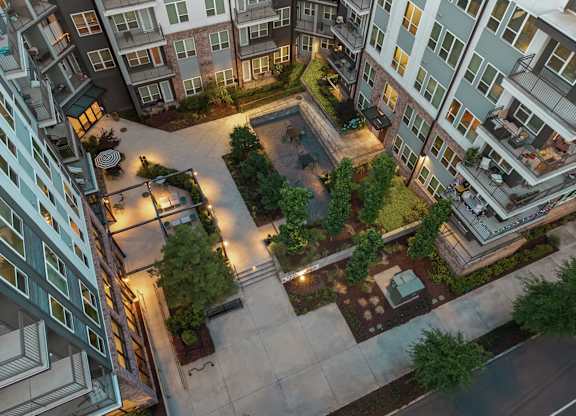 A courtyard surrounded by apartment buildings at night.