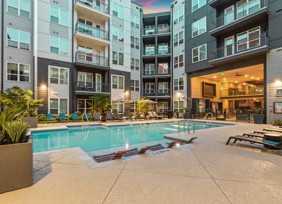 A large swimming pool in front of apartment buildings.
