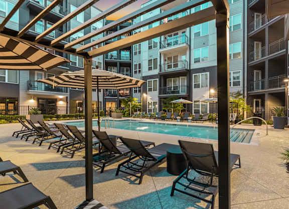 A pool area with sun loungers and a canopy.