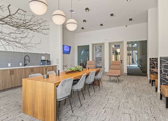 A modern dining room with a long table and chairs.