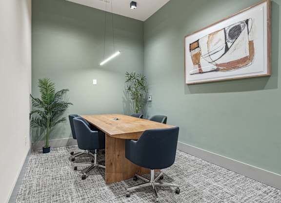 A conference room with a wooden table and blue chairs.