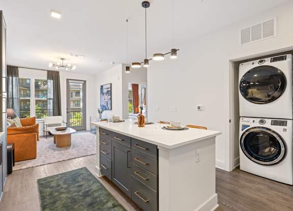 A modern laundry room with a washer and dryer built into the cabinetry.