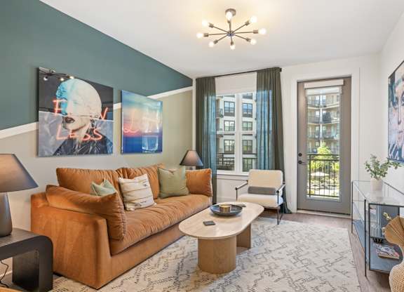 A living room with a brown couch, a coffee table, and a painting on the wall.