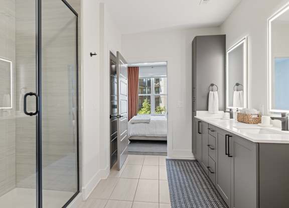 A bathroom with a walk-in shower and a double vanity.
