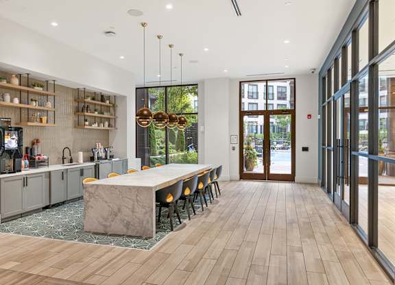 A modern kitchen with a marble island and wooden floors.