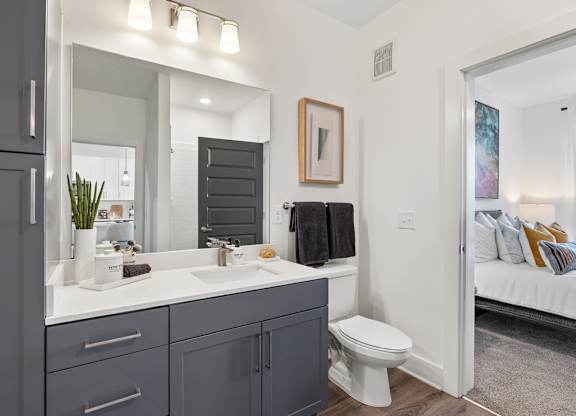 A bathroom with a white countertop and a white toilet.