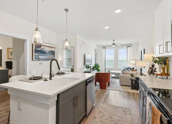 A modern kitchen with a large island and pendant lights.