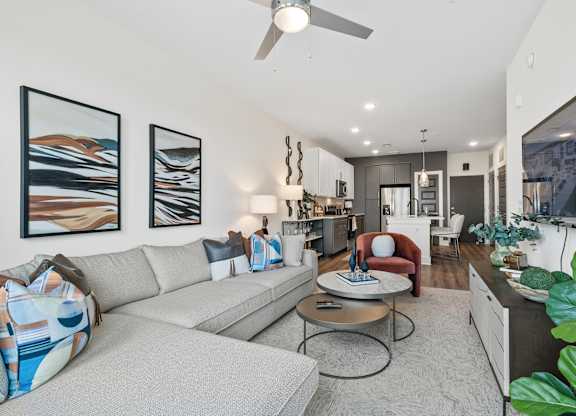 A modern living room with a grey sofa, a coffee table, and a television.