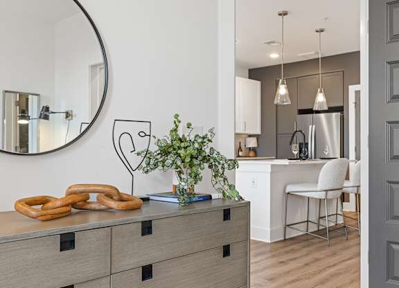 A kitchen with a round mirror and a plant on the counter.