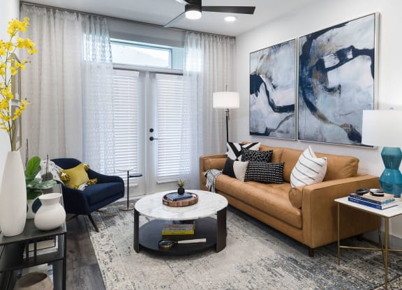A living room with a brown couch, a coffee table, and a painting on the wall.