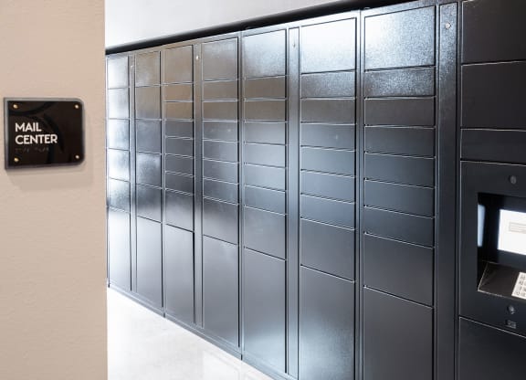A row of mailboxes are lined up next to a wall.