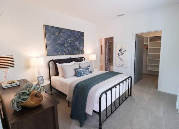 a bedroom with a bed and a painting on the wall