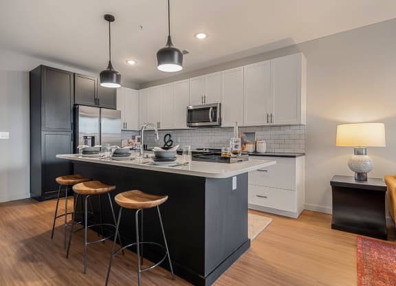 a kitchen with a large island with three stools
