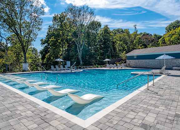 A large outdoor swimming pool surrounded by trees.