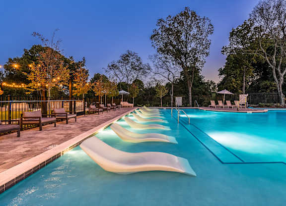 A long, lit, outdoor pool with steps.