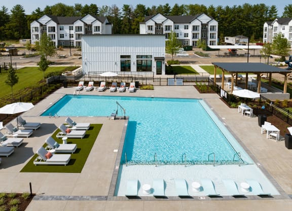 an aerial view of a swimming pool with lounge chairs around it