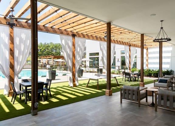 a communal area with tables and chairs and a swimming pool