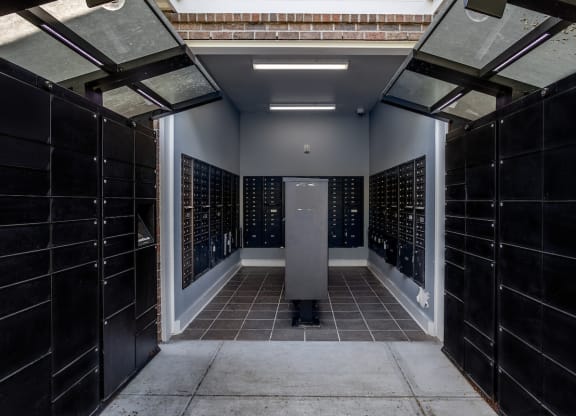 a look down a hallway with black tiles and a gray column in the middle