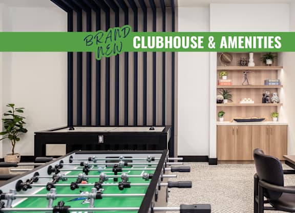 A foosball table is in the middle of a room with a green table top.