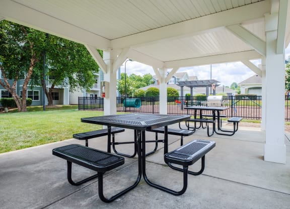 a covered picnic area with benches and tables