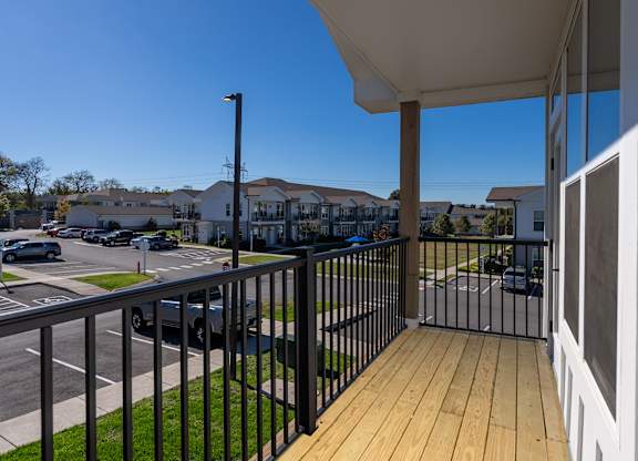 A balcony with a black railing and a white wall.
