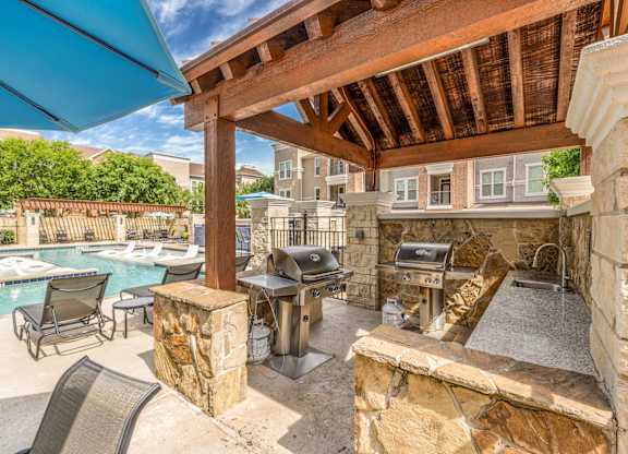 A patio with a grill and a pool table.