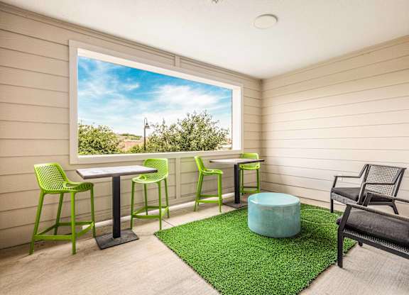 A balcony with a table and chairs overlooking a blue sky.