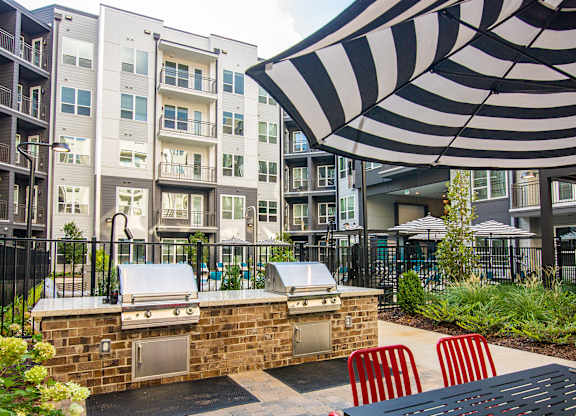 our apartments have a large outdoor patio with a grill and an umbrella