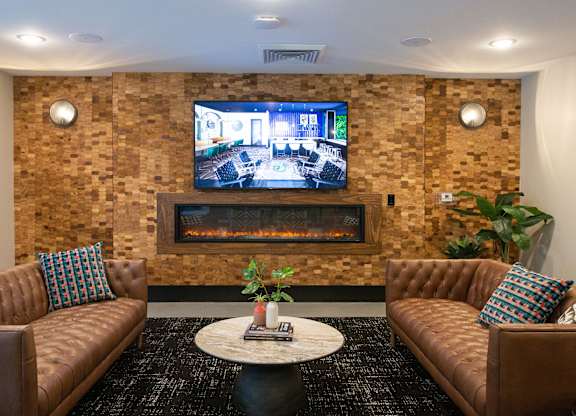 a living room with couches and a television on the wall