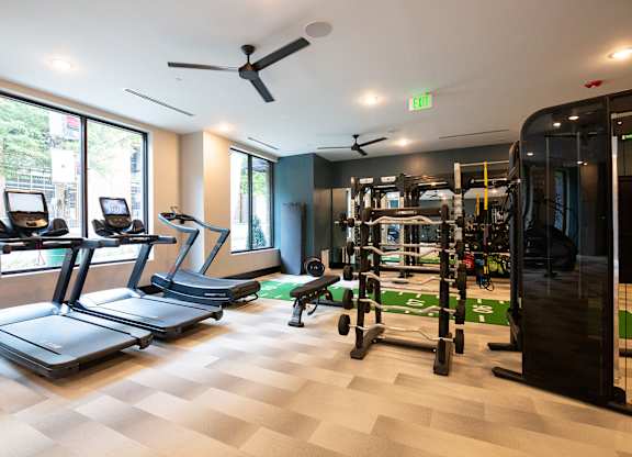 a gym with cardio machines and weights on a checkered floor