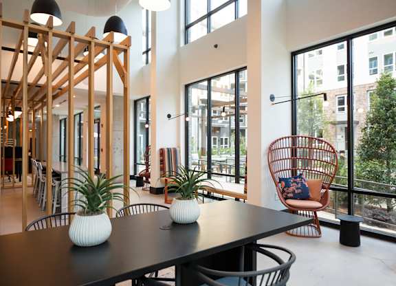 a dining room with a table and chairs and large windows