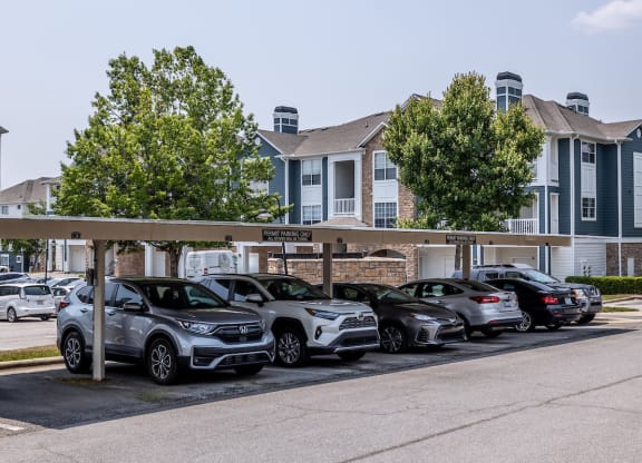 a row of cars parked in a parking lot in front of a building