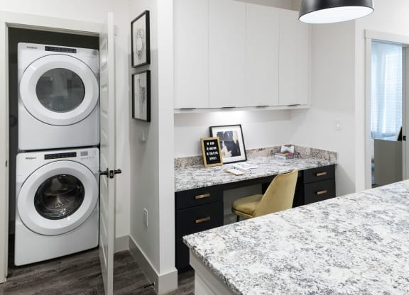 a washer and dryer in a kitchen with a counter top and a sink