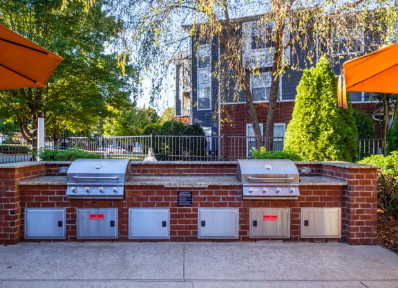 a brick barbecue with four ovens on it in front of a house