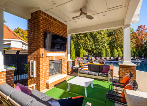 a backyard with a fireplace and a pool with lounge chairs and a table