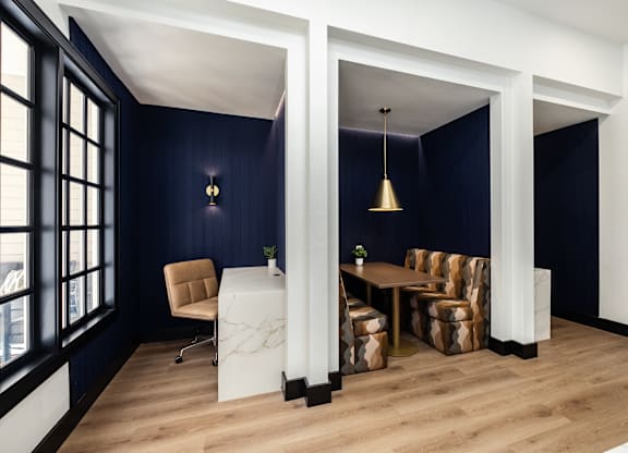 A room with a white table and chairs with a blue wall.