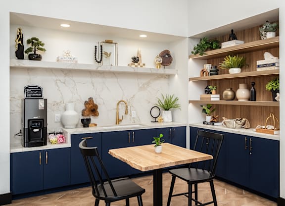 A kitchen with a table and chairs in the middle.