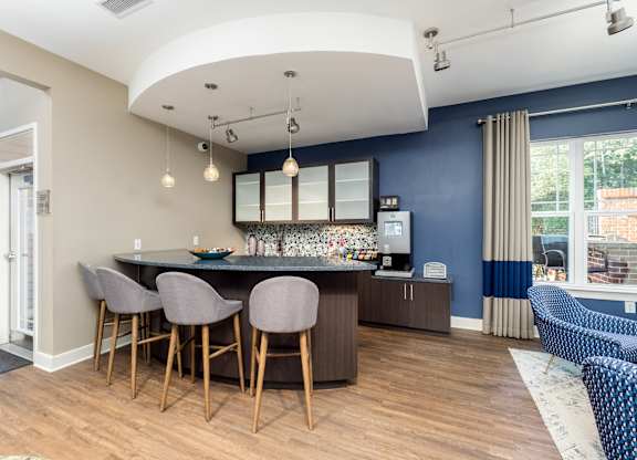 A kitchen with a bar area and chairs.