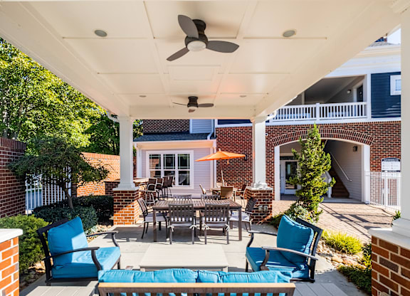 a patio with a table and chairs and a ceiling fan
