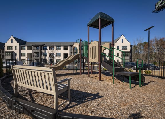 a playground with a slide and a bench in a park