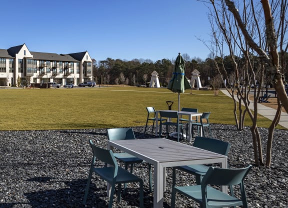 a park with tables and chairs in front of a building