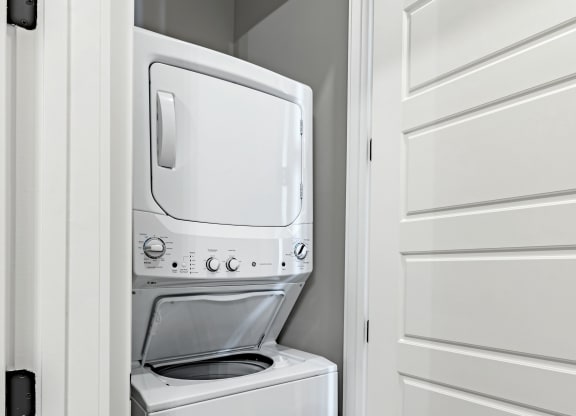a white washer and dryer in a laundry room with a white door