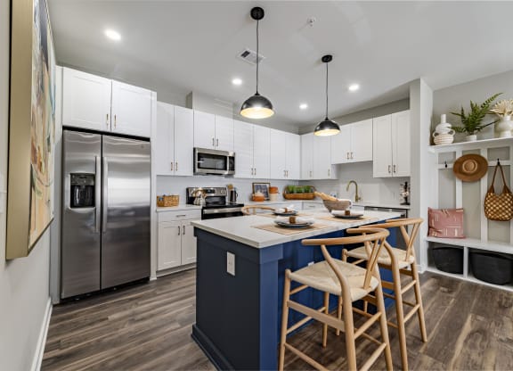 kitchen with island with stools and a stainless steel refrigerator