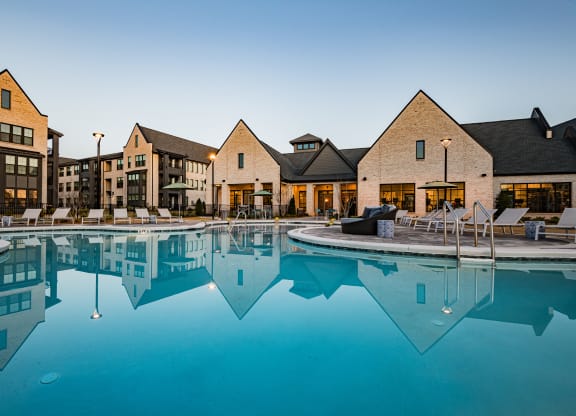 a large swimming pool with apartments in the background