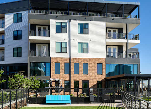 A modern apartment building with a green lawn in front.