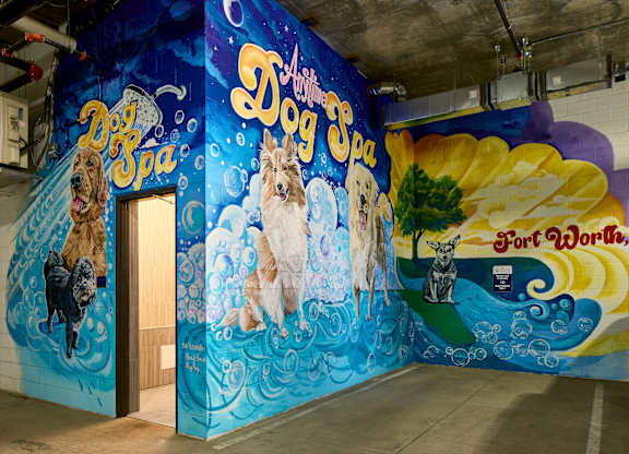 A mural of dogs painted on a wall in a room.