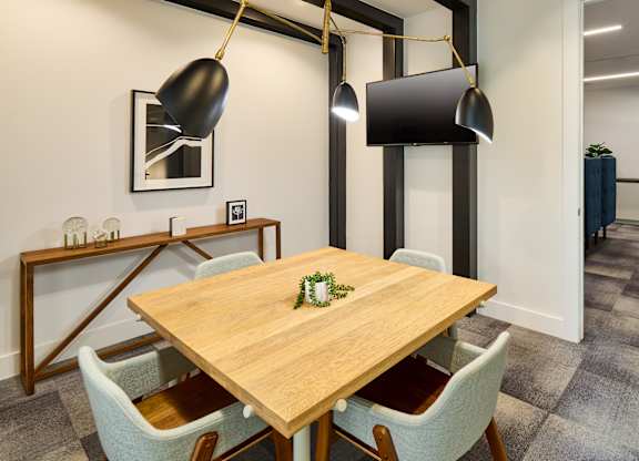 A dining room with a wooden table and chairs.