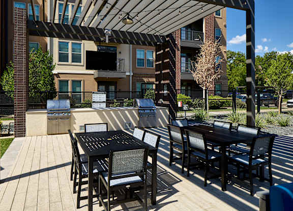 A patio with a table and chairs is in front of a building.